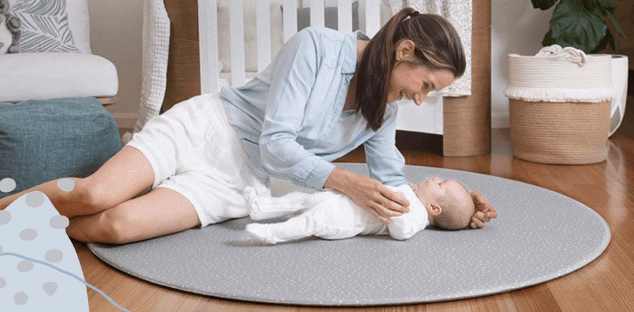 Mum and baby laying on a padded foam play mat